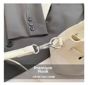 Detail of high-quality silver hook and cream leather strap on woven bucket bag