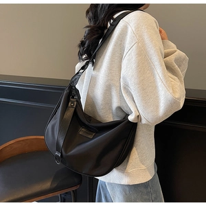 Detailed back view of the large black nylon crescent hobo bag worn on a model's shoulder