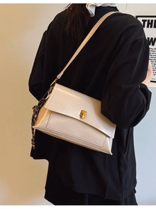 Sac bandoulière crème en cuir huilé vintage avec foulard et boucle dorée sur blazer