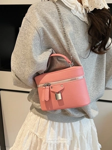 Pink lychee leather mini vanity crossbody bag with silver chain strap worn by a model