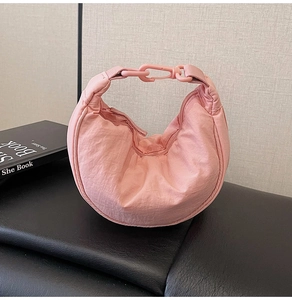 Detailed view of pink pleated nylon crescent bag with matching plastic buckle link