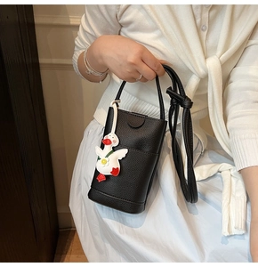 Vue détaillée du sac à téléphone noir grainé avec un charmant canard blanc