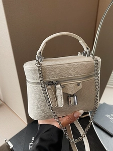 White lychee pattern box handbag with silver padlock and chain strap in hand