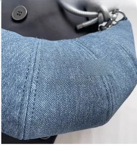 Detailansicht der hellblauen Jeans-Tasche mit Steppmuster und modischem Schriftzug