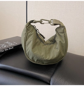 Detailed view of an olive green nylon crescent bag with textured fabric and top zipper