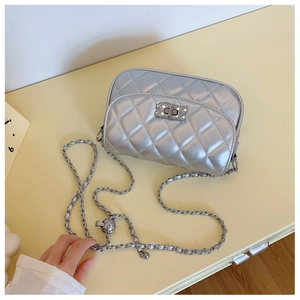 Close-up of silver quilted crossbody bag with luxury metallic twist lock and chain strap