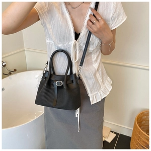 Detail of black woven bucket bag with smooth leather splicing and elegant handle