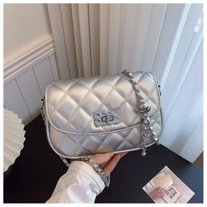 Detailed macro view of silver quilted texture and metallic buckle on chain bag