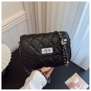 Detail of black quilted leather chain bag with silver metallic clasp and decorative ball