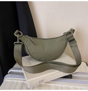 Detail of army green nylon crescent bag with wide adjustable shoulder strap and matte hardware