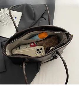 Vista dall'alto dell'interno spazioso di una borsa tote in pelle marrone con oggetti