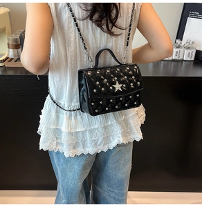 Detailed view of quilted black bag with silver studs and crystal star on lace top model