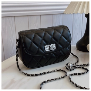 Detail of black quilted leather crossbody bag featuring silver turn-lock and chain strap