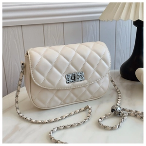 Detail of quilted beige chain bag with metal turn-lock and adjustable ball chain