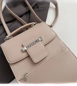 Detail der mandelfarbenen Handtasche aus Kunstleder mit Silberkette und Nietenbesatz