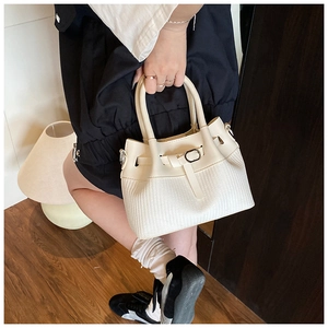 Detailed view of woven bucket bag with leather strap and twin cylinder handles