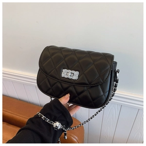 Detail of black quilted leather crossbody bag with silver twist lock and chain strap