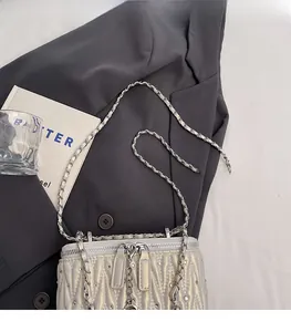 Detail of silver quilted handbag with rhinestones on grey blazer with luxury scene