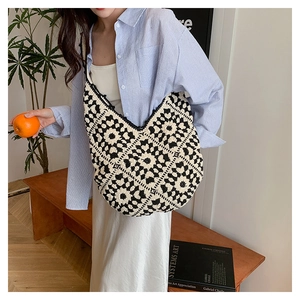 Detail of hand-crocheted tote bag featuring black and white floral geometric patterns