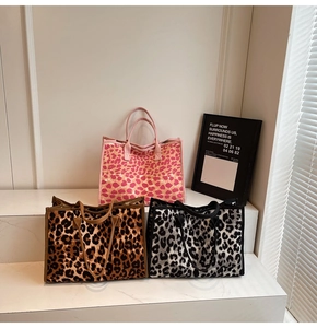 Three leopard print tote bags in pink, brown, and grey displayed on marble steps
