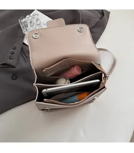 Draufsicht auf das geräumige Drei-Fächer-Innenleben einer beigefarbenen Lederhandtasche