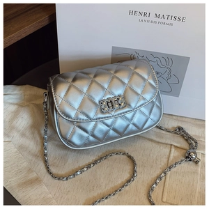 Detail of silver metallic crossbody bag featuring quilted rhombus pattern and chain strap