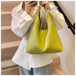 Detail of avocado green bucket bag showing premium lychee texture and vertical stitching