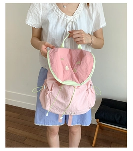 Detail of pink watermelon backpack with green trim and drawstring side pockets