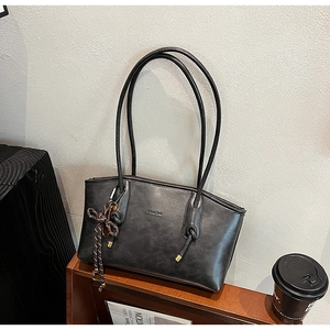 Dettaglio della borsa tote vintage grigia con spalline sottili e ciondolo intrecciato