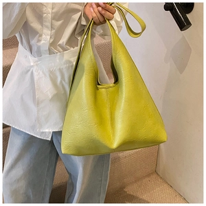 Shoulder shot of mustard green PU leather bucket tote bag with stylish vertical stitching