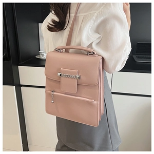 Detailansicht der rosa Umhängetasche mit Metallkette und dekorativem Kugelanhänger