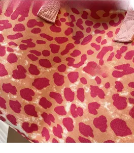Macro shot of orange leopard print canvas fabric with pink woven strap details