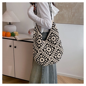 Macro view of woven crochet tote bag with black and white floral pattern texture