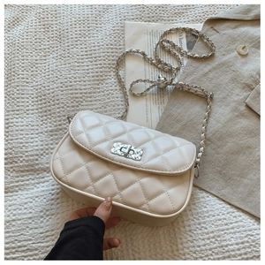 Close-up of quilted leather texture and silver chain strap on cream crossbody bag