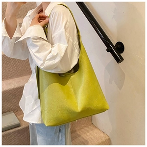 Close-up of lemon green hobo bag featuring soft pebble leather texture and stitching