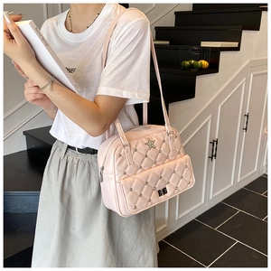 Detail of pink quilted handbag with star logo, studs and front flap pocket design