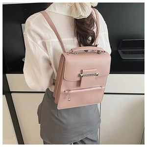 Detail der rosa Lederhandtasche mit Metallkettendekoration und glatter matter Textur