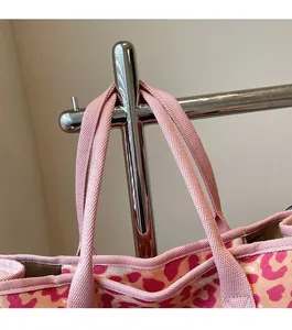 Detail of pink leopard print tote bag featuring durable reinforced woven shoulder straps