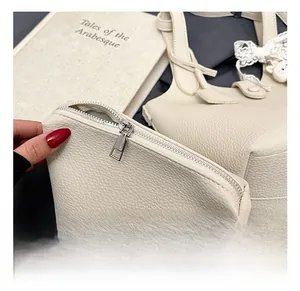 Detail of cream white lychee grain bucket bag with lace bow and rabbit charm