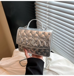 Close-up of silver quilted crossbody bag featuring star rhinestone and metal chain strap