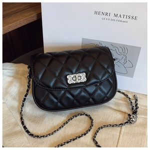 Detail of classic black quilted crossbody bag featuring silver chain and woven metal lock