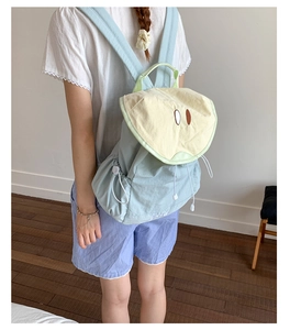 Detailed side view of macaron color backpack with functional drawstring pocket and cute eyes