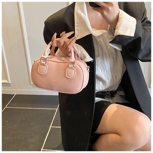 Detail of light pink pebble grain leather bowling bag with silver hardware accents