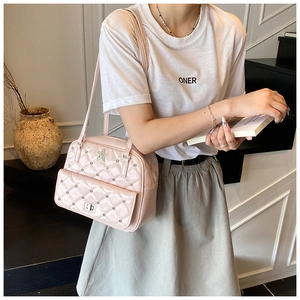 Close-up of pink quilted tote with silver studs and a metallic star on smooth faux leather
