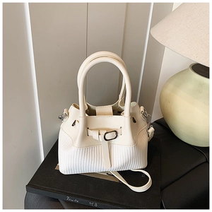 Detail of off-white woven bucket bag with smooth PU leather trim and metal buckle