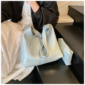 Detail of mint green tote bag with natural pleated texture and matching zipper pouch