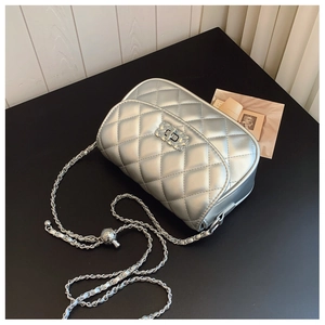 Close-up of silver quilted crossbody bag with metal chain strap and decorative turn-lock