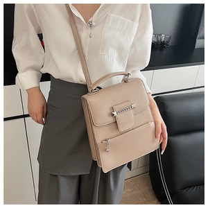 Seitenansicht einer apricotfarbenen Ledertasche mit Lychee-Struktur und Metallkette