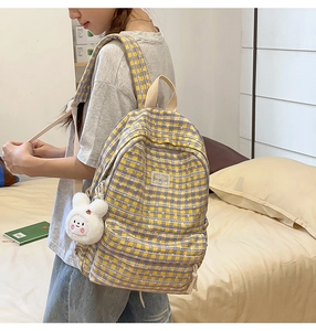 Detail of purple and yellow plaid canvas backpack with a cute white bunny plush charm