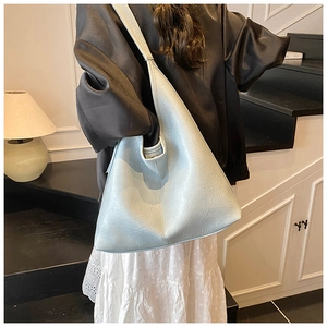 Detail of mint blue leather bucket bag showing soft texture and triangular structure